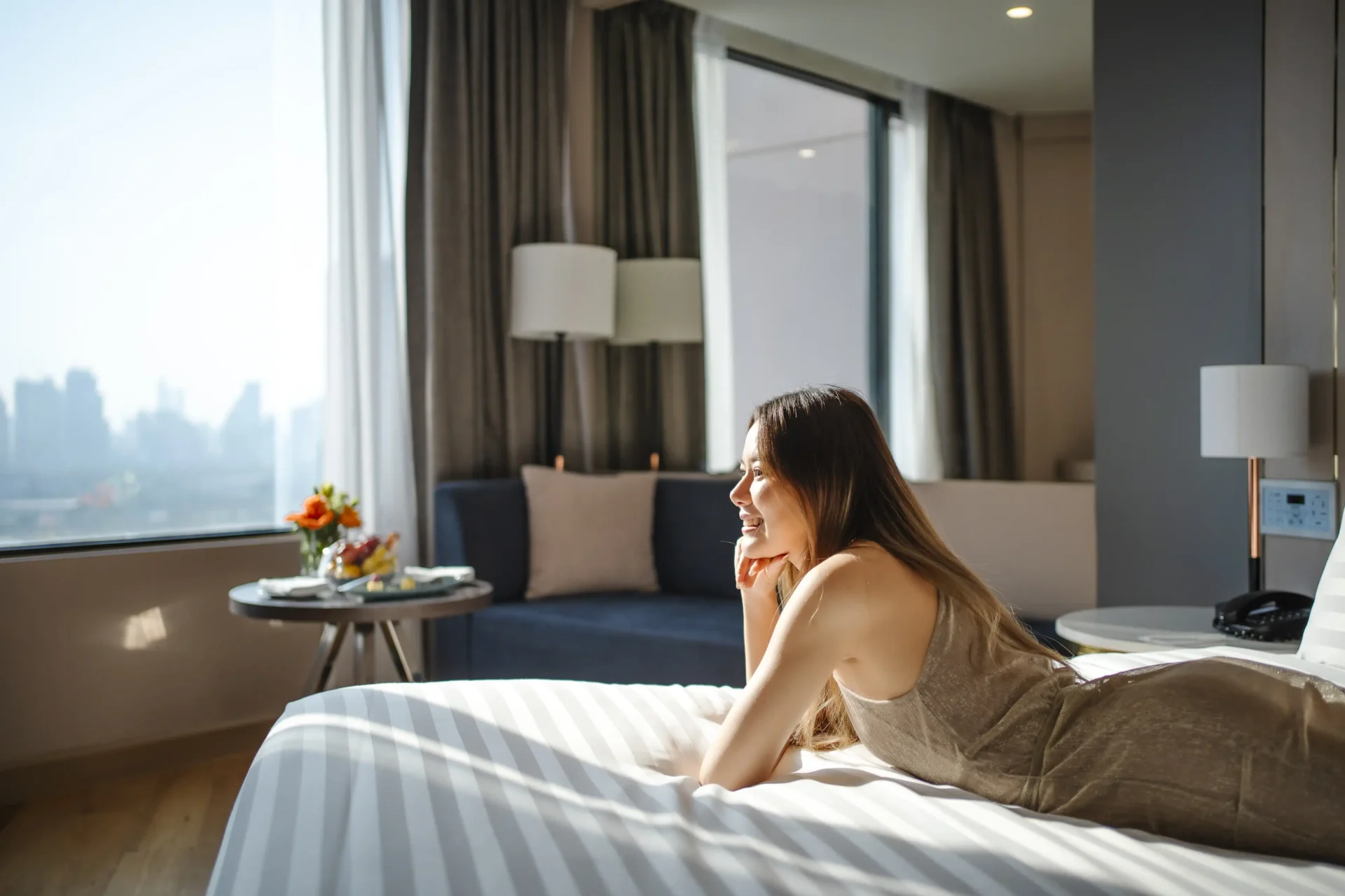 Guest relaxing in Bangkok hotel room with panoramic city view in Sukhumvit near BTS